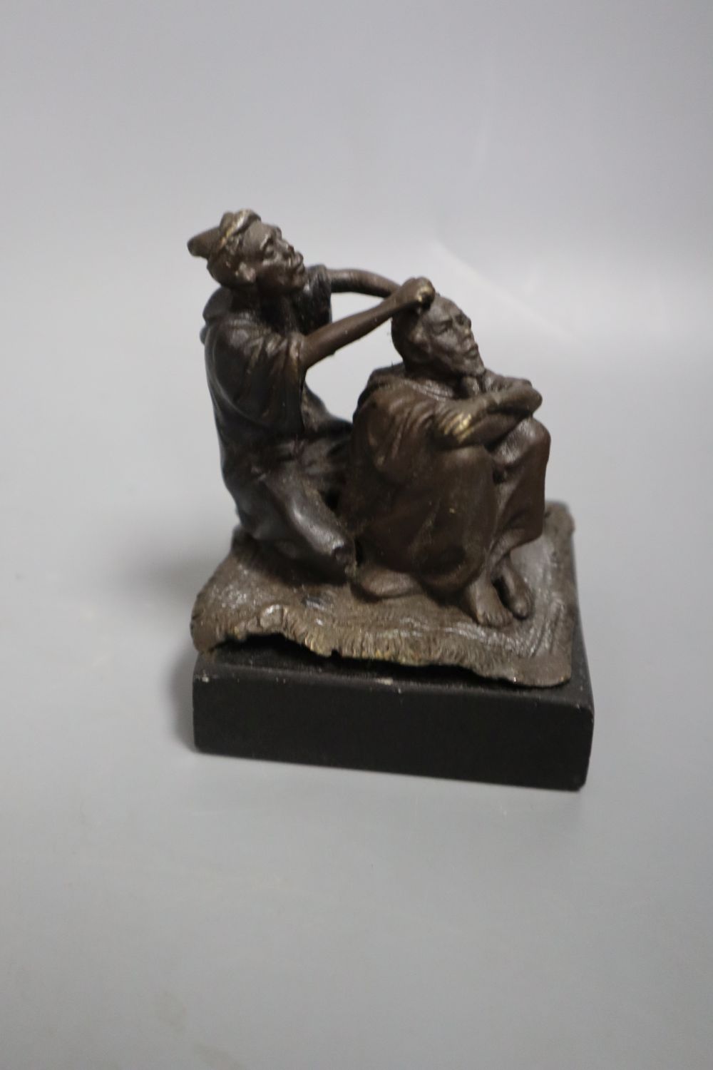 A cast metal sculpture Kiss after Rodin, height 14cm and another of Arabs